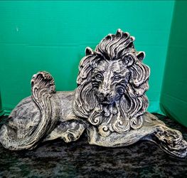 Reclining lion statue featuring  highly detailed mane with rustic, aged finish. 23" long