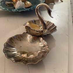 This is a vintage silver-plated serving dish with a swan and shell design.