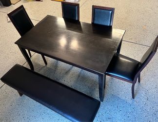Dark brown table with four matching chairs and bench