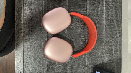 Apple AirPods Max in the Pink (coral/red) color with matching smart case.