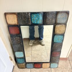 wall mirror with a multi-colored, tiled frame