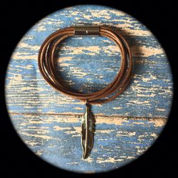 ** Men’s multi-wrap brown leather bracelet with magnetic clasp and metal pendant.