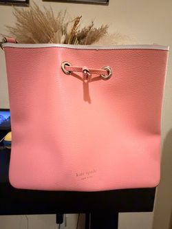 Kate Spade pink pebbled-leather bucket/crossbody-style bag with drawstring closure.