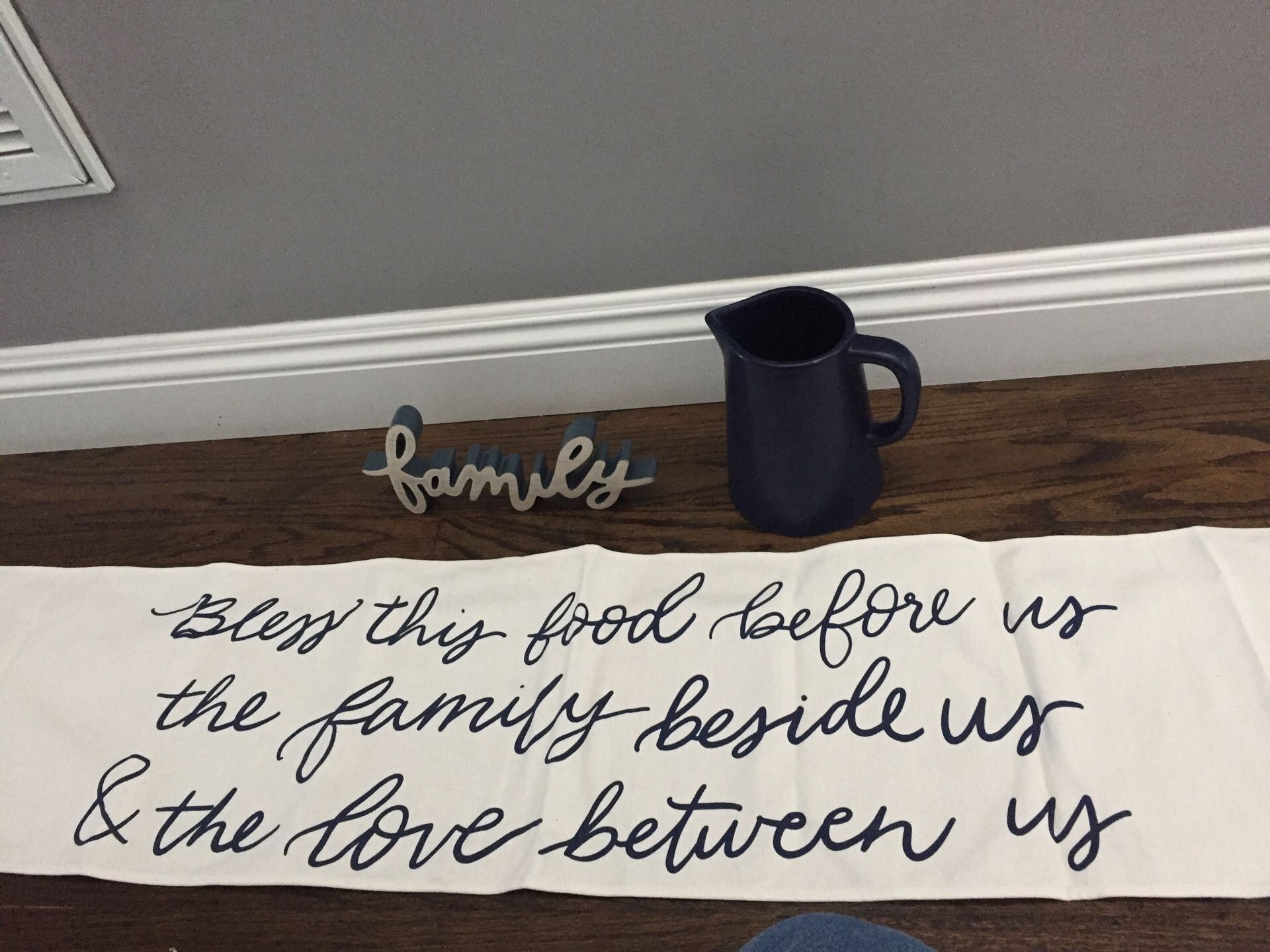 New table runner with wooden family sign and ceramic pitcher