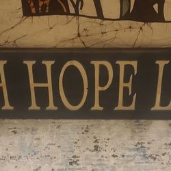 Wooden wall plaque features the phrase "FAITH HOPE LOVE," a popular inspirational quote