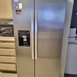 Whirlpool side-by-side fridge and freezer with water dispenser and ice maker.
