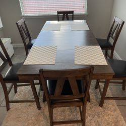 Dining set with a table and six bar stools. Folds out.