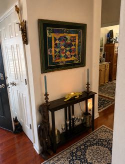 Beautiful framed textile artwork measuring 35” x 35”. This unique piece features vibrant colors and an eye catching patchwork design that adds charact