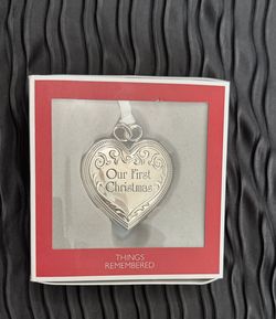 heart-shaped, silver-tone ornament features a locket design