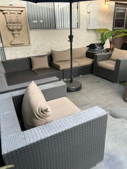 Rattan patio set with minor damage (shown in the photos); some cushions are missing.