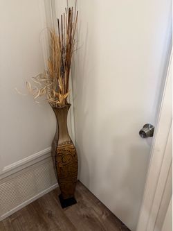 Tall metal vase thing with dried stuff