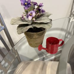 Purple artificial flower with watering can candle tea light holder