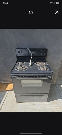 freestanding black electric range (stove and oven combo) with four traditional coil heating elements on the cooktop.