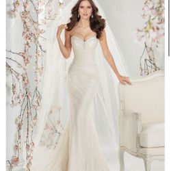 wedding dress. Featuring a sweetheart n eckline accented with c rystal. She features a corset closure in the back.