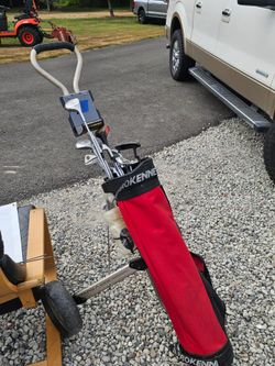 Older set of golf clubs and hand cart