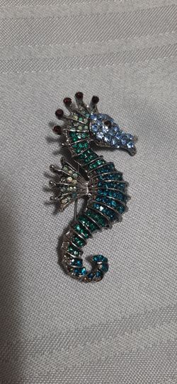 seahorse brooch featuring blue & green stones