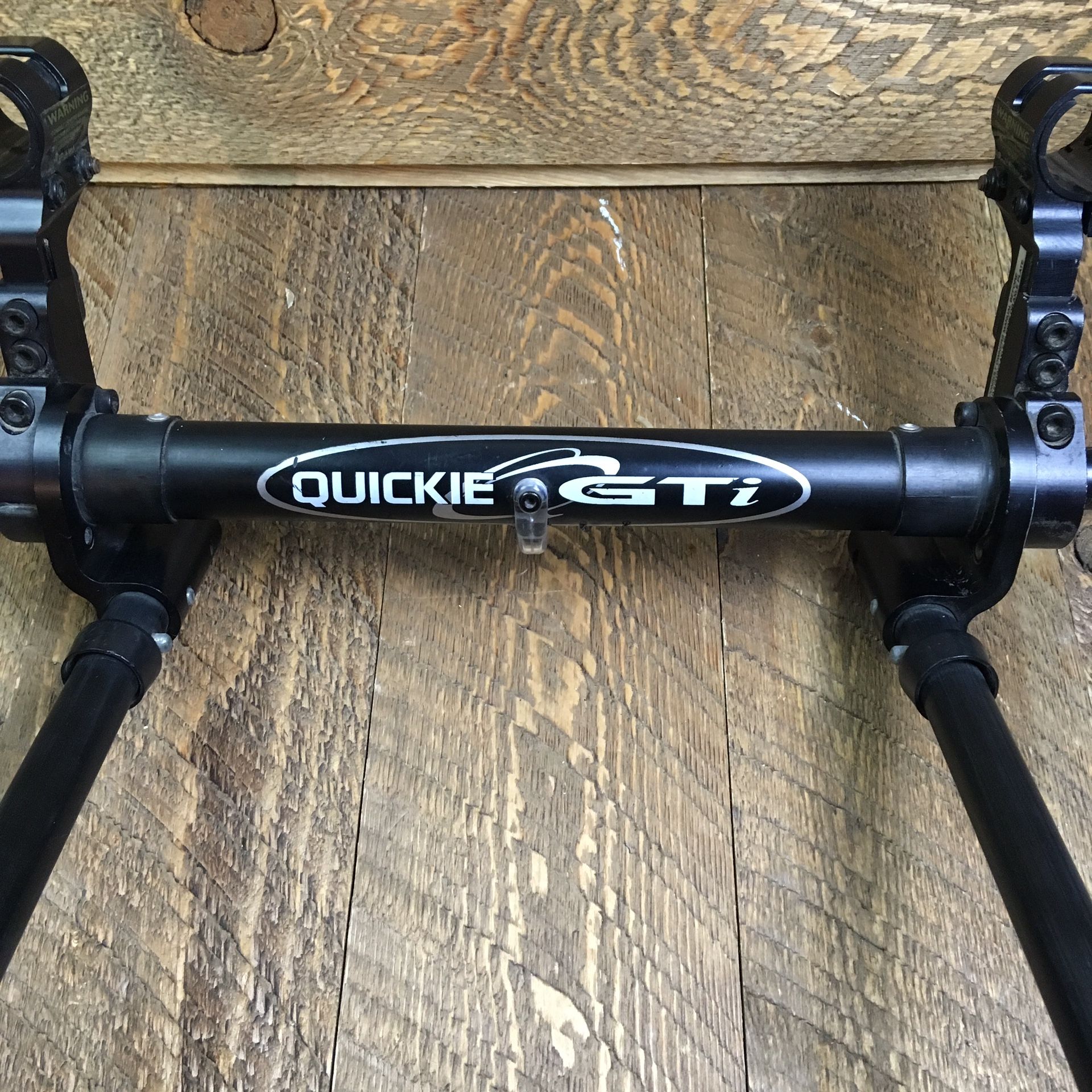 Quickie GTi wheelchair rear axel assembly with wheelie bars