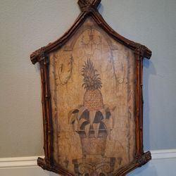 Decorative wall art featuring a pineapple in a bamboo frame