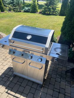 Grill, stainless steel, propane, iron cast crate, side burner, sear side burner. Needs new regulator hose.