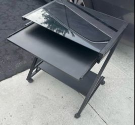 Desk 26” long glass top , with h wheels good condition