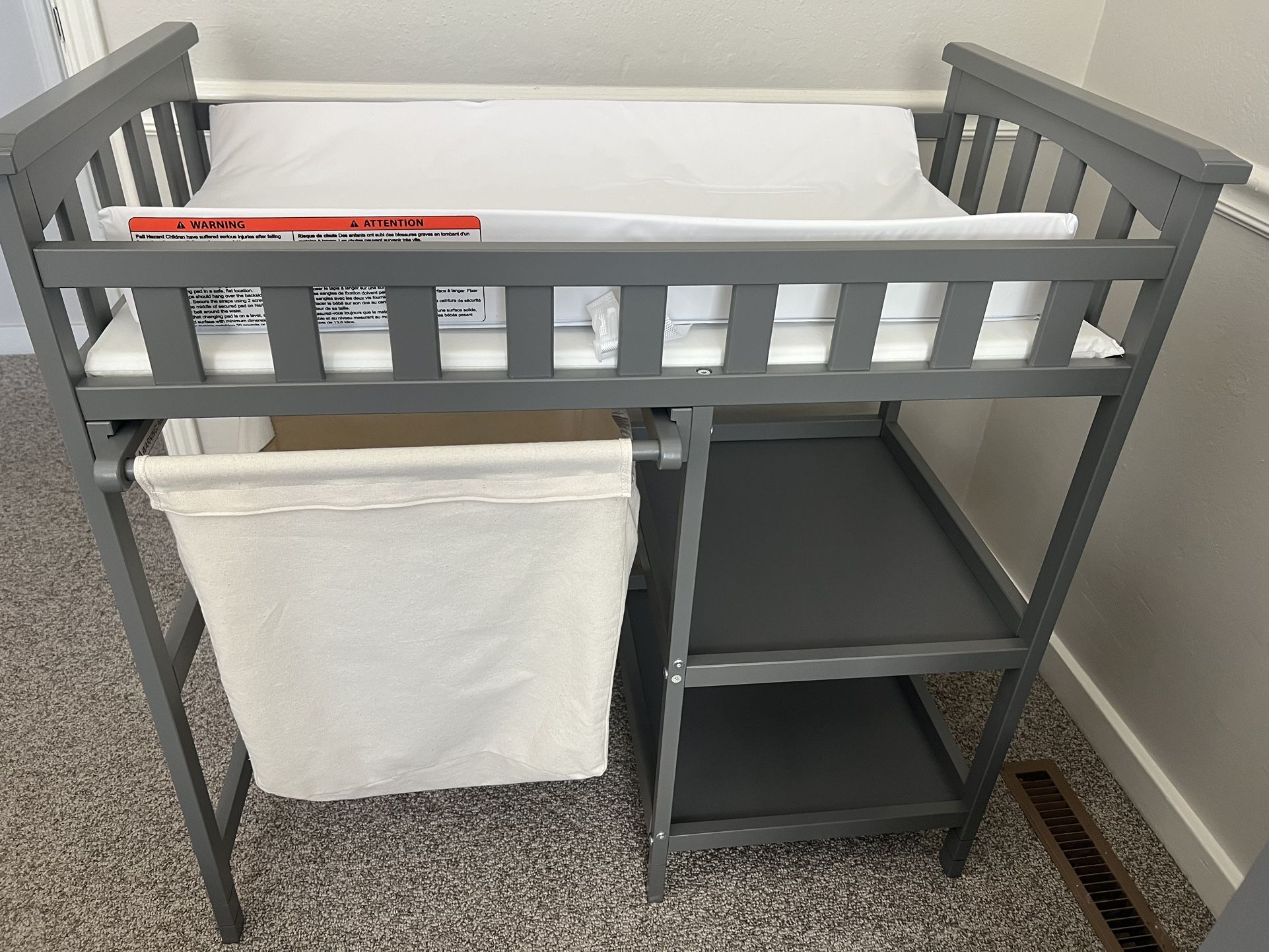 gray changing table with hamper and shelves