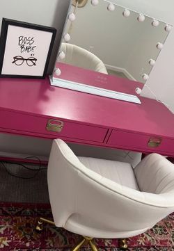 beautiful pink vanity set with a Hollywood-style lighted mirror and a white swivel chair