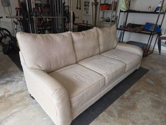 Light beige, three-cushion fabric sofa with rolled arms and welt-corded trim