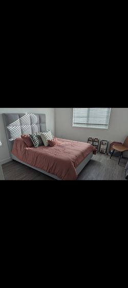 Grey upholstered queen bedframe with drawers