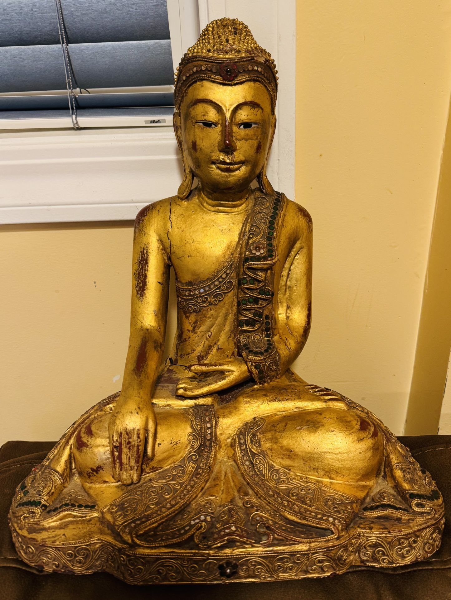 antique Thai Buddha statue likely from the 19th century in the Mandalay style. It is made of wood and gilded with gold leaf.