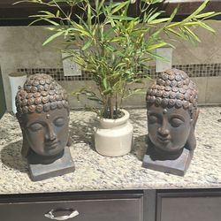 Two Buddha heads and bamboo plant