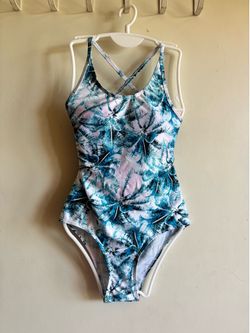Comfortable one-piece swimsuit with a tropical palm print. Soft stretch fabric provides a snug, flexible fit. Cross-back straps add secure support and