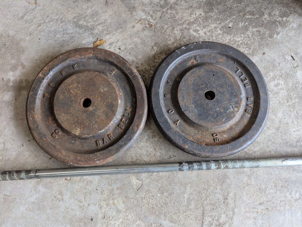 Two 50 lb. York metal weights with heavy duty lift bar.
