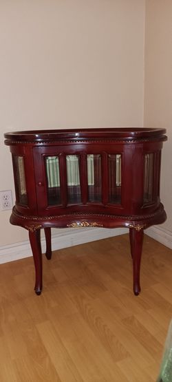 A vintage kidney-shaped wood curio display and tea table.