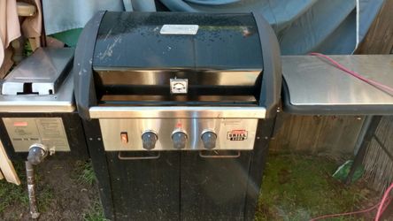 Coleman BBQ with a deep fryer on the side and a work table on the other side