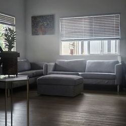 A set of two gray sofas and an ottoman 