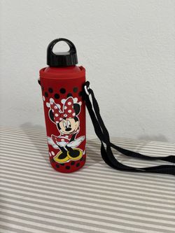 Minnie Mouse water bottle with a red, polka-dotted carrier and a black shoulder strap. 