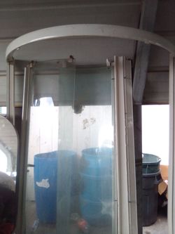 Jacuzzi tub, corner shower glass enclosure, toilet and sink.  Tile