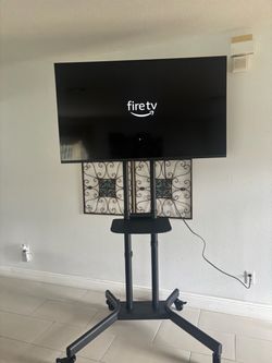 Insignia TV on Rolling TV Stand and remote control size 50”