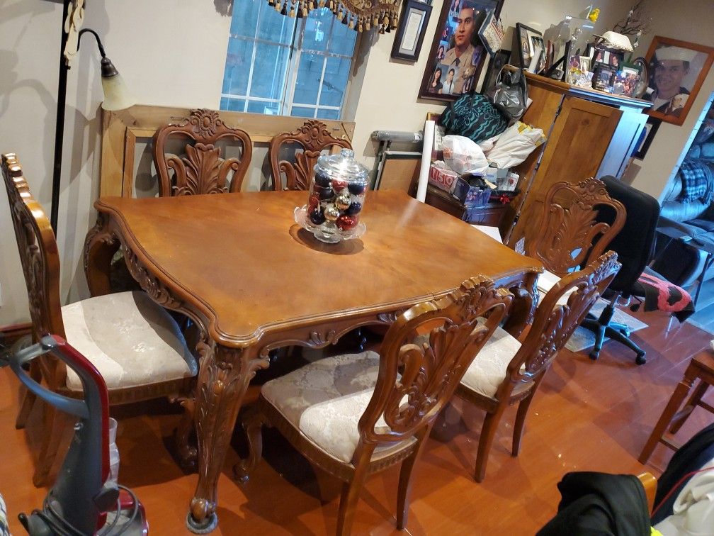 6 chairs 1 leg is broken on the arm has leaf in the middle to expand