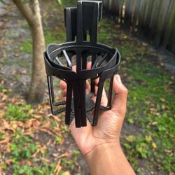 black plastic cup holder designed to fit into a car window channel or door panel