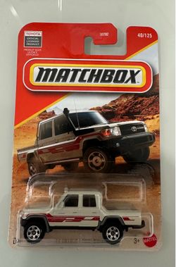 New Matchbox '17 Toyota Land Cruiser pick up truck 78 die-cast metal toy truck. This white vehicle has red side graphics and a black front bumper. It 