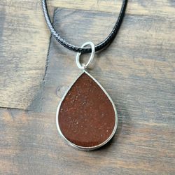 Stardust Teardrop Orgonite Pendant, Provides EMF Protection, And  Balance. 

Contains: 
Red jasper, black obsidian, metal, and resin. 

"Embark on a j