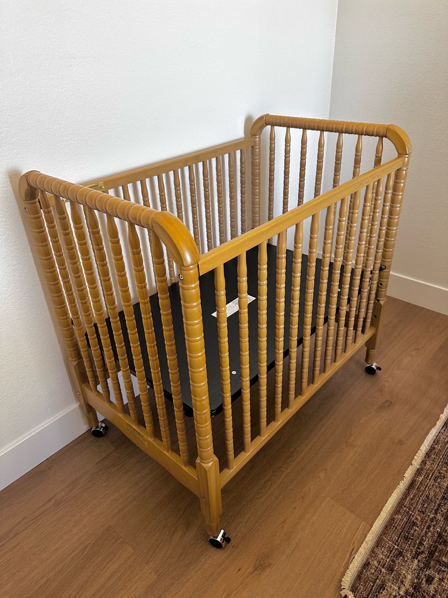 Like New solid wood Mini Crib with removable wheels
