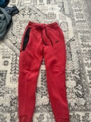 Red Nike tech pants
