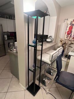 Modern tall shelf floor lamp with a black rectangular frame, glass shelves, and an illuminated top