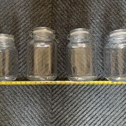 Preowned set of four large glass jars for sugars etc