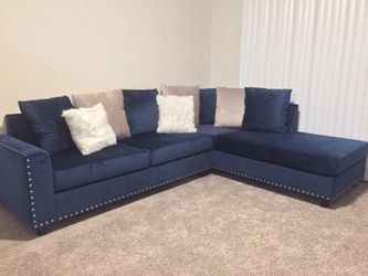 Brand new velvet upholstered sectional with nail head trim.