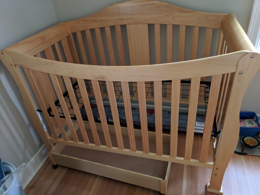 Crib with changing table, storage drawer, and toddler bed attachment