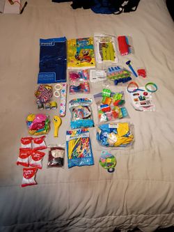 A large collection of Birthday Party Supplies Including a SpongeBob Themed Banner/Bag , Foil Fringe Curtain, Table Cover, Various Assorted Party Ballo