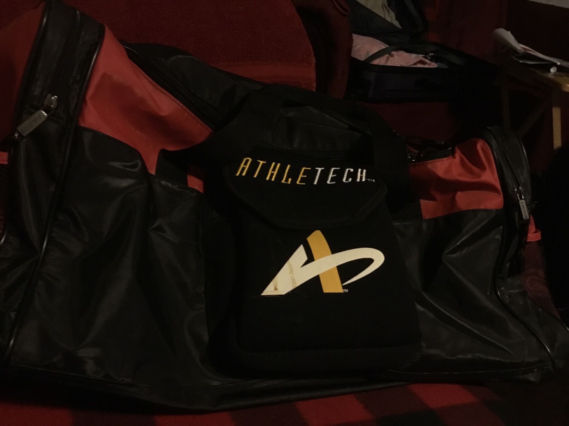 A red and black duffer bag brand name is athlete he